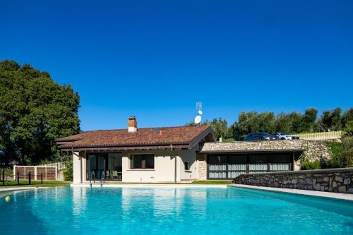 a house with a swimming pool in front of a house at Villa Anna Lake View in Pilzone