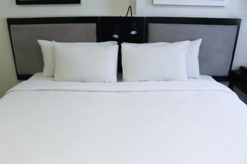 a bedroom with two beds with white sheets and pillows at Summit Hotel Magnolia in Manila