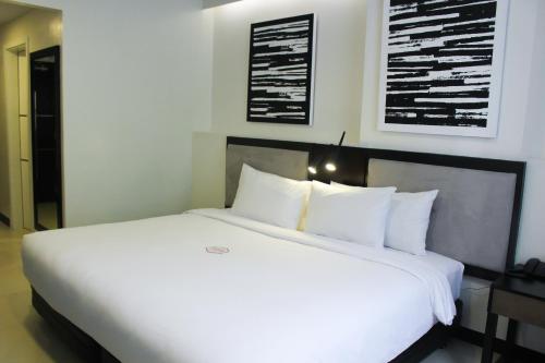 a large white bed in a hotel room at Summit Hotel Magnolia in Manila