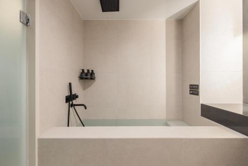 a bathroom with a shower with a glass door at Cave Ryokan Hotel by Aank Sungshin Women's University in Seoul