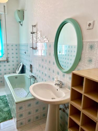 a bathroom with a sink and a tub and a mirror at Casa Nicola - Welchome in San Vito Chietino