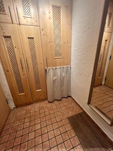 a bathroom with wooden doors and a tiled floor at Hanna's Home in Kitzbühel