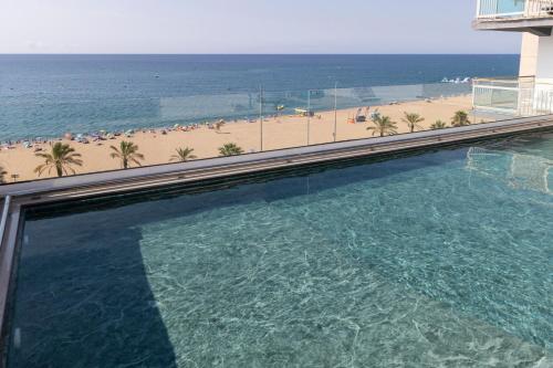 a swimming pool with a view of the beach at Hotel Calella by Beatriz Hoteles in Calella