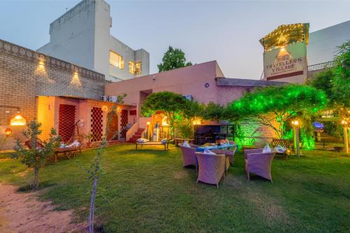 a yard with chairs and tables and a building at Travellers Village-City Center Hertige Home in Jaipur