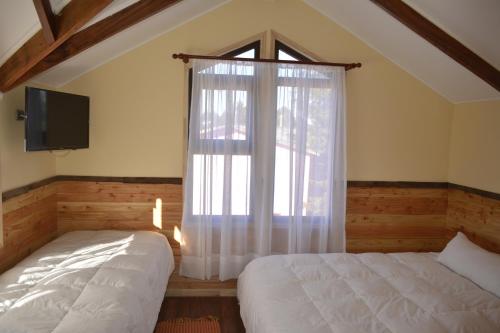 Katil atau katil-katil dalam bilik di Cabañas Estacion del Lago