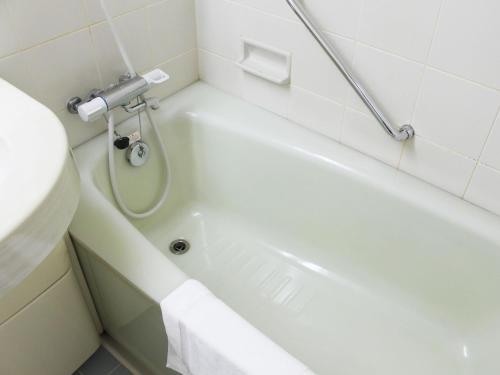 ein Badezimmer mit einer Badewanne, einem WC und einem Waschbecken in der Unterkunft Hotel Trend Mito in Mito