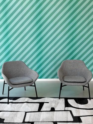 two chairs sitting in front of a striped wall at NEW OPENING 2025 aparto Florence Manifattura in Florence