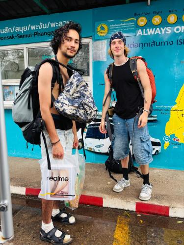 two men standing on a street holding a bag at Baansrisuthum in Don Sak