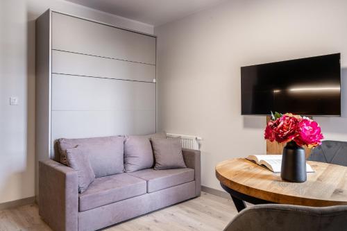 a living room with a couch and a table at Symphony City Square Aparthotel in Wrocław