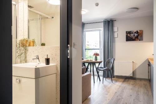 a kitchen and dining room with a sink and a table at Symphony City Square Aparthotel in Wrocław