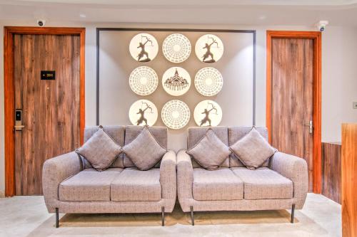 a living room with a couch and plates on the wall at Clubhouse Hotel Ayodhya in Ayodhya