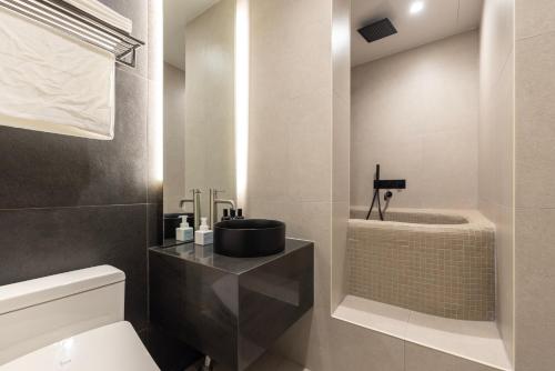 a bathroom with a sink and a toilet and a tub at Cave Ryokan Hotel by Aank Sungshin Women's University in Seoul