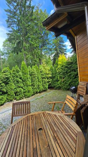 a wooden table and chairs on a patio at Józefina Apartament's blisko centrum in Szklarska Poręba
