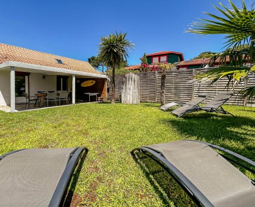 un patio con 2 sillas de jardín y una casa en Escapade à Capbreton, proche mer & commerces, en Capbreton
