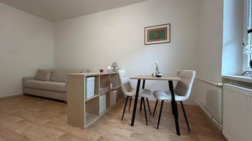 a living room with a table and chairs and a couch at Bílý klid nově zrekonstruované studio in Děčín