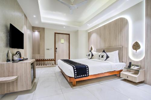 a bedroom with a large bed and a bathroom at Clubhouse Hotel Ayodhya in Ayodhya