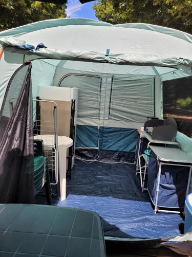 a large tent with a table and a desk at Camping Le Soulhol in Saint-Céré