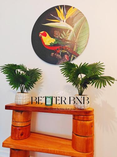 a sign on top of a wooden shelf with two plants at Affordable Value 3 Cozy Beds 2 Smart Rooms in Lower Hutt