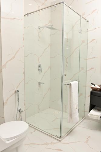 a glass shower stall in a bathroom with a toilet at Villa Vista in Islamabad