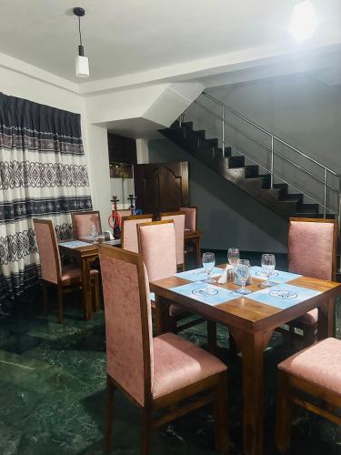a dining room with tables and chairs and a staircase at Bluebell hotel and family restaurant in Sri Jayewardenepura Kotte