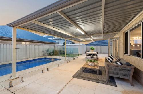 an open patio with a table and a pool at Spacious Stay near Karrinyup in Perth