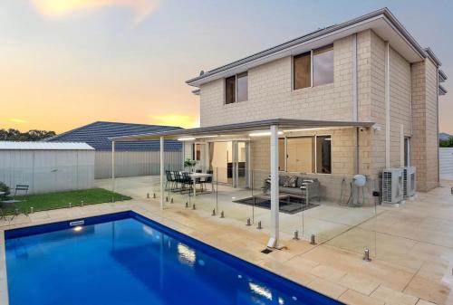 a house with a swimming pool in front of a house at Spacious Stay near Karrinyup in Perth