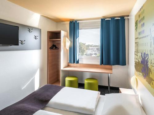 a small room with a bed and a window at B&B Hotel Braunschweig-Nord in Braunschweig
