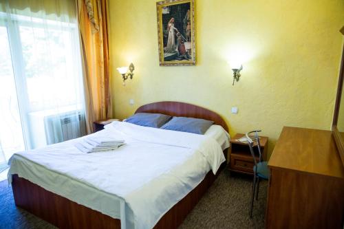 a bedroom with a large bed with white sheets at Славна Кача in Odesa