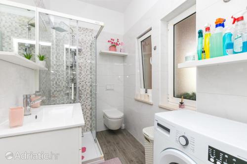 a white bathroom with a shower and a toilet at Apartment Radalj in Kaštela