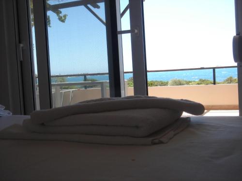 a stack of towels on a bed in front of a window at Villa-Palaiochora in Palaiochóra