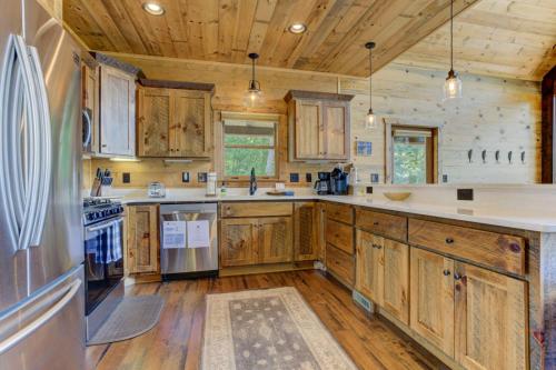a kitchen with wooden cabinets and a refrigerator at Little Creek Cabin - Game Room with Media Space, Outdoor TV Lounge, Hot Tub + Firepit in Blue Ridge