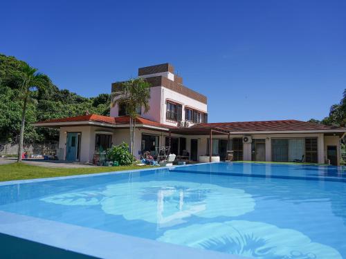 a large swimming pool in front of a house at SOLAIZ Ishigaki Island in Kabira