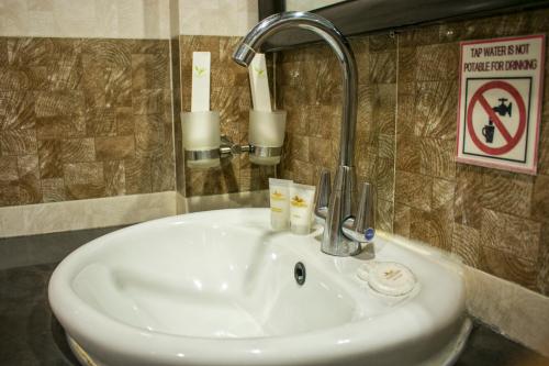 a sink with a faucet in a bathroom at Paradise Garden Hotel and Convention Center Boracay Powered by ASTON in Boracay