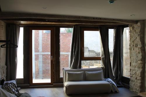 a living room with a couch in front of a window at Patio y Calados Rioja Suites in Cenicero