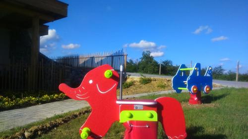 a toy dinosaur is sitting in the grass at Guest House Eco Vila Mila in Rogaška Slatina