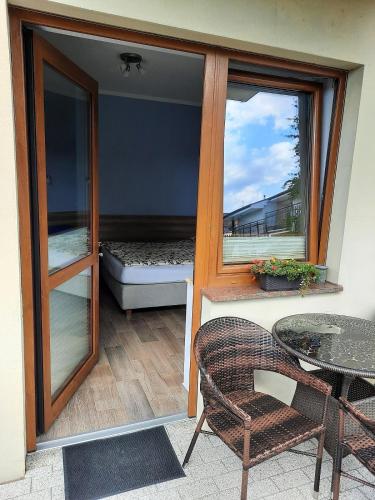 a balcony with a bed and a table and a window at Pokoje gościnne GRYF in Rewal