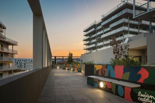 einen Balkon eines Gebäudes mit Sonnenuntergang im Hintergrund in der Unterkunft Moxy Nice in Nizza
