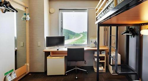 an office with a desk with a computer and a window at Super Hotel Arai-Niigata in Myoko