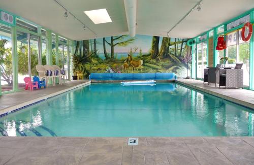 a swimming pool in a building with a mural at Slumber Lodge in Hope