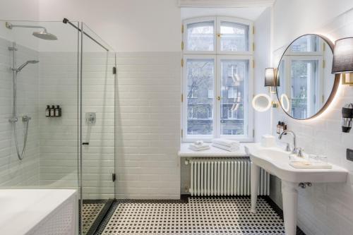 a white bathroom with a sink and a shower at Movenpick Hotel Tallinn in Tallinn