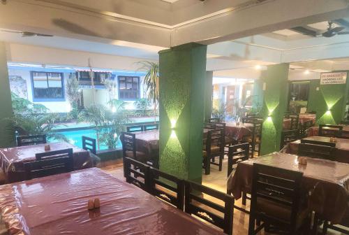 a dining room with tables and green pillars in a restaurant at Calangute Beachside Apartment by Welkin stays in Calangute