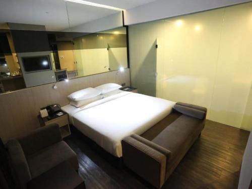 a bedroom with a large white bed and a chair at Seeds Hotel Premier One City Subang Previously eCity Hotel One City in Subang Jaya