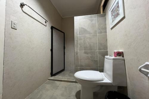 a bathroom with a toilet and a shower at Vista Venice Resort in Morong
