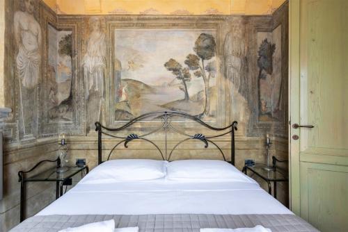 a bedroom with a bed with a painting on the wall at IseoLakeRental - La Colombaia in Monte Isola