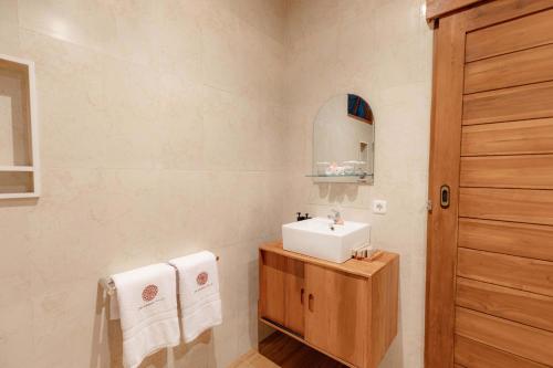 a bathroom with a sink and a mirror at Uma Nandhi Villa Ubud in Tegalalang