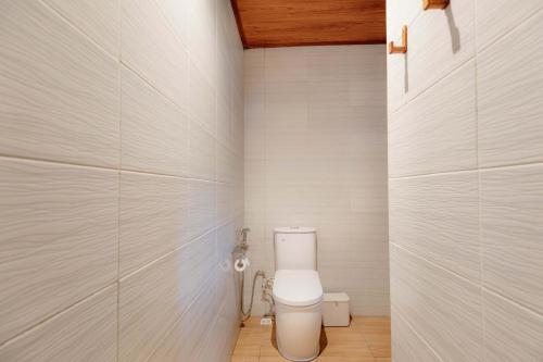 a bathroom with a white toilet in a room at Uma Nandhi Villa Ubud in Tegalalang