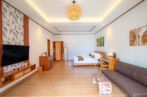 a living room with a couch and a flat screen tv at Uma Nandhi Villa Ubud in Tegalalang