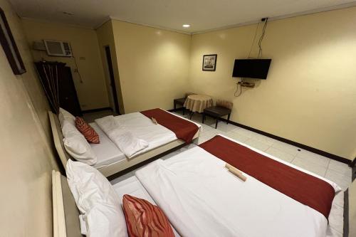a hotel room with two beds and a television at Vista Venice Resort in Morong
