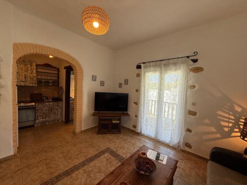 a living room with a large window and a television at Atlazia Suites in Alinda