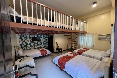 a bedroom with two beds and a bunk bed at Vista Venice Resort in Morong